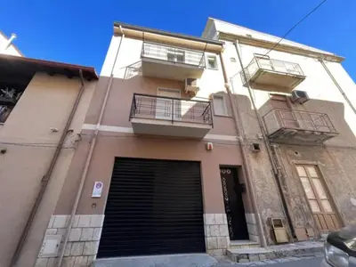 a building with two balconies and a garage at CASA VACANZE PERLA in Partinico