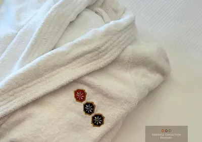 a close up of two buttons on a white blanket at Heritage Collection Palermo B&B in Palermo