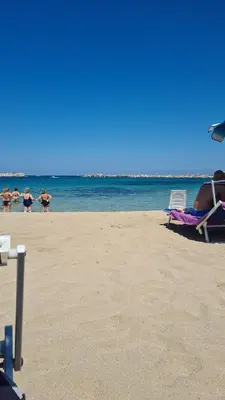 a group of people playing in the water on a beach at Holiday House Giorgia in Terrasini