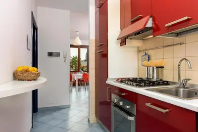 a kitchen with red cabinets and a sink at Paprica&Zenzero in San Vito lo Capo