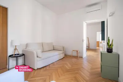 a living room with a white couch and wooden floors at Casa Mirto a Piazza Marina by Wonderful Italy in Palermo