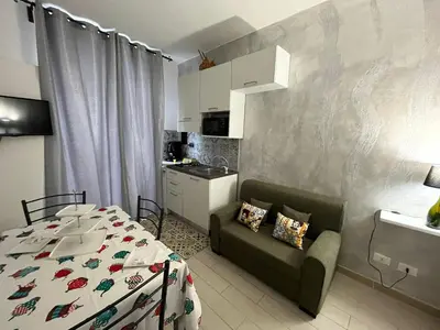 a living room with a bed and a kitchen at Capobeb in Palermo