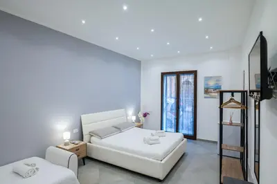 a white bedroom with a bed and a couch at Baron’s Suites in Palermo
