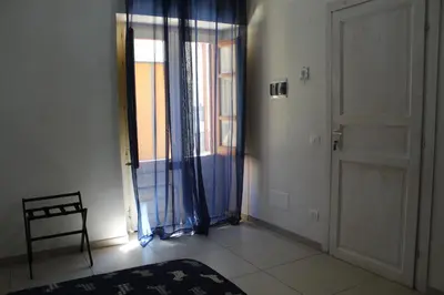 a room with a door and a chair and a window at La Melagrana in Castellammare del Golfo