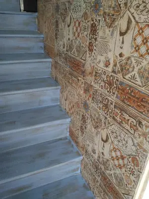 a wall with mosaics on the side of a staircase at La Melagrana in Castellammare del Golfo