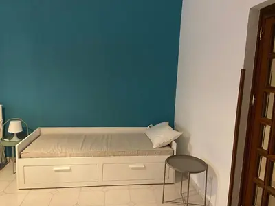a bedroom with a bed with a blue wall at Cortile Cascino Home in Palermo