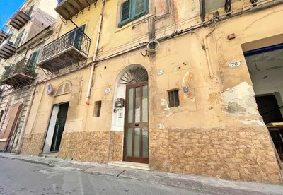 an old stone building with a door on a street at Monfenera Little Apartments in Palermo