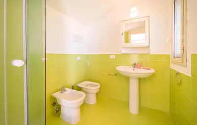 a green bathroom with a sink and a toilet at Beautiful Home In Altavilla Milicia in Altavilla Milicia