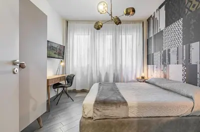 a bedroom with a large bed and a desk at GuestHost - Al Qasr Design and Luxury Flat - Palermo Center in Palermo