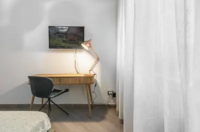 a bedroom with a desk with a lamp and a chair at GuestHost - Al Qasr Design and Luxury Flat - Palermo Center in Palermo