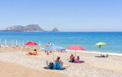 a group of people sitting on a beach with umbrellas at 2 Bedroom Amazing Home In Trabia in Trabia