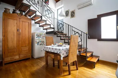 a kitchen with a table with chairs and a staircase at La Terrazza Sullo Spasimo in Palermo
