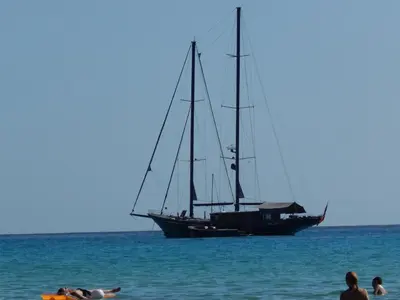 a sail boat in the ocean with people on the beach at Casa Vacanze Karol in Trappeto