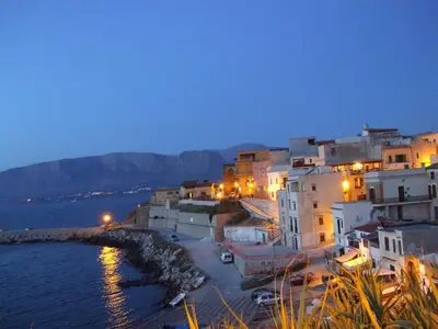 a group of buildings next to the water at night at Casa Vacanze Karol in Trappeto