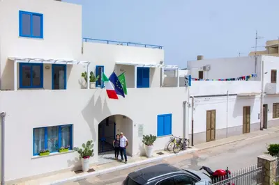 a group of people standing outside of a white building at Hotel Arte Mare - camere in via del mulino 45 in San Vito lo Capo