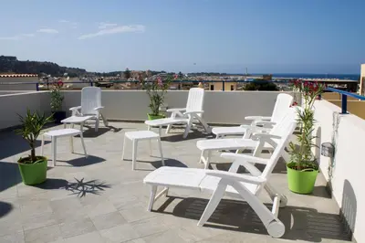 a row of white chairs sitting on a roof at Hotel Arte Mare - camere in via del mulino 45 in San Vito lo Capo