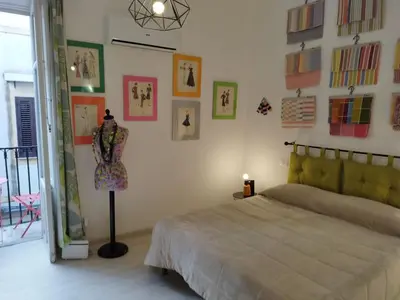 a bedroom with a bed and some pictures on the wall at The tailor's house in Palermo