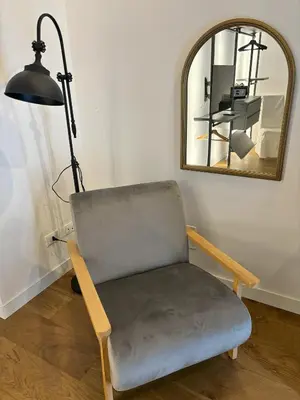 a chair in a room with a mirror and a lamp at Olivuzza 27 in Palermo