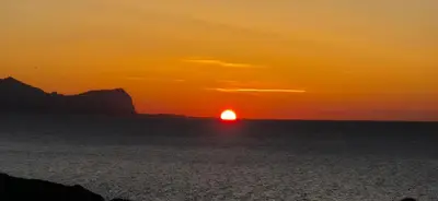 a sunset over the ocean with the sun in the sky at NONNA ADRIANA in Terrasini