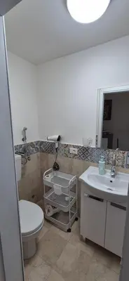 a bathroom with a toilet and a sink and a mirror at NONNA ADRIANA in Terrasini