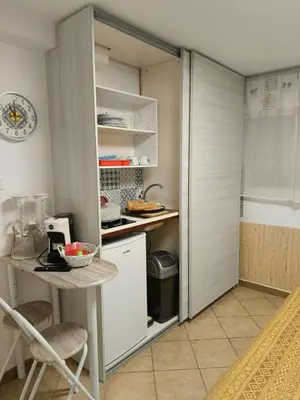 a small kitchen with a refrigerator and a table at Sicily guest house in Palermo