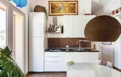a kitchen with a white refrigerator and a table at Appartamento nel centro storico di Palermo in Palermo
