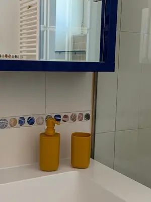 a bathroom with two yellow containers sitting on a sink at MaDà holiday house ideale per coppie o famiglie in Palermo