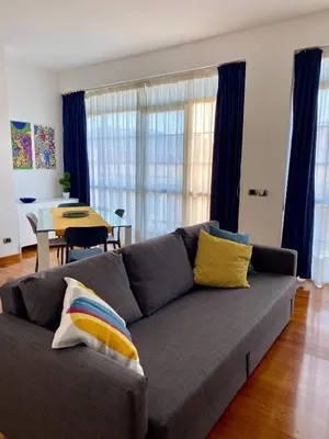 a living room with a gray couch and a table at MaDà holiday house ideale per coppie o famiglie in Palermo