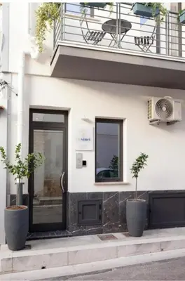 a building with two potted plants in front of a door at Holiday House Vitruvian in Terrasini