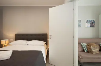 a bedroom with a bed and a couch at Holiday House Vitruvian in Terrasini