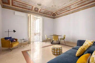 a living room with a blue couch and a table at Verosicily Sant'Elia suite in Palermo