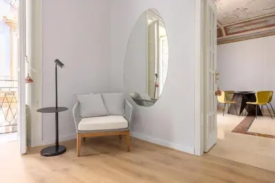a chair and a mirror in a room at Verosicily Sant'Elia suite in Palermo