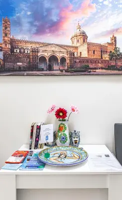 a table with a picture of a large building at Sicily Trinacria House in Palermo