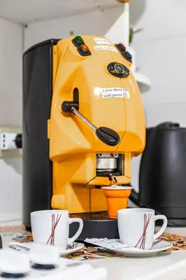 a yellow coffee machine sitting on a table with two cups at Sicily Trinacria House in Palermo