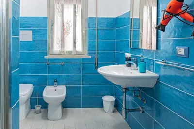 a blue bathroom with a sink and a toilet at Sicily Trinacria House in Palermo