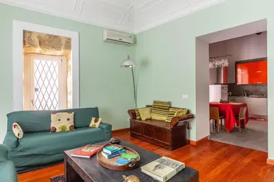a living room with a green couch and a table at Casa Professa Luxury Palermo Center in Palermo
