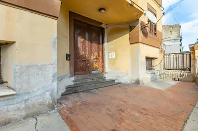 a building with a brown door and a brick sidewalk at GuestHost - Ballarò Market Cozy Apartments in Palermo