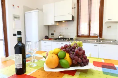 a plate of fruit on a table with a bottle of wine at Costa Mediterranea Holiday Homes in Campofelice di Roccella