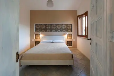 a bedroom with a bed and a window and a door at Villa Corallo Cala Bianca in Castellammare del Golfo