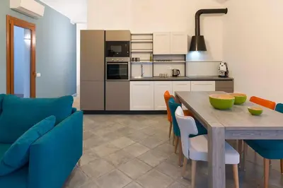 a kitchen and dining room with a wooden table and chairs at Villa Corallo Cala Bianca in Castellammare del Golfo