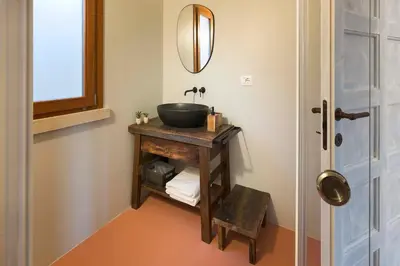 a bathroom with a sink and a mirror on a table at Villa Corallo Cala Bianca in Castellammare del Golfo