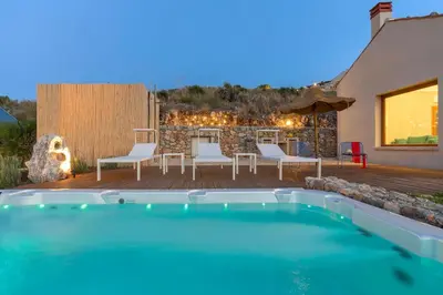 a backyard with a swimming pool and a table and chairs at Villa Corallo Cala Bianca in Castellammare del Golfo