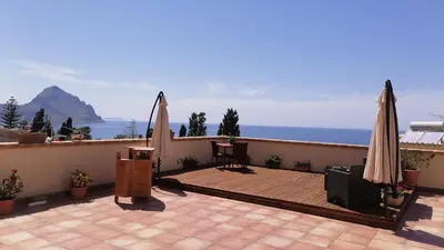 a balcony with umbrellas and a view of the ocean at Kalura B&B in Macari