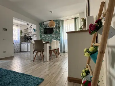 a living room and dining room with a table and chairs at Relais Rosa Apartment in Palermo