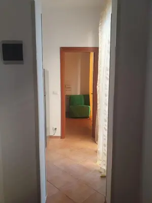 a hallway with a room with a green bed at La Casetta del piano di sopra in Palermo