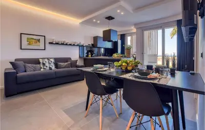 a kitchen and living room with a table and chairs at 2 Bedroom Awesome Apartment In Trappeto in Trappeto