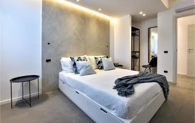 a bedroom with a large white bed with a concrete wall at 2 Bedroom Awesome Apartment In Trappeto in Trappeto