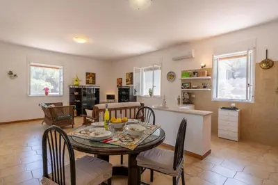a dining room and kitchen with a table and chairs at Casa gli Oleandri in Castellammare del Golfo