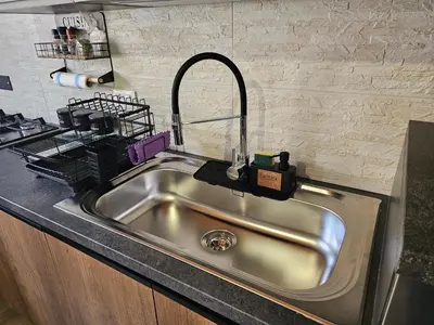a stainless steel kitchen sink with a black counter top at Appartamento Vista Stazione in Palermo