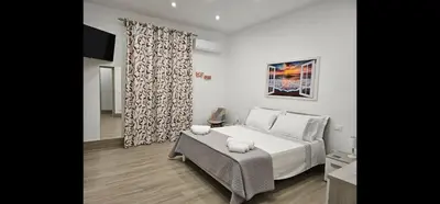 a bedroom with a large white bed and a couch at Appartamento Vista Stazione in Palermo